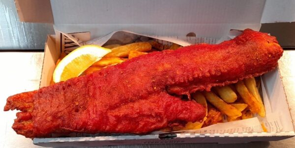 Battered Masala Cod and Chips in a box with a lemon wedge